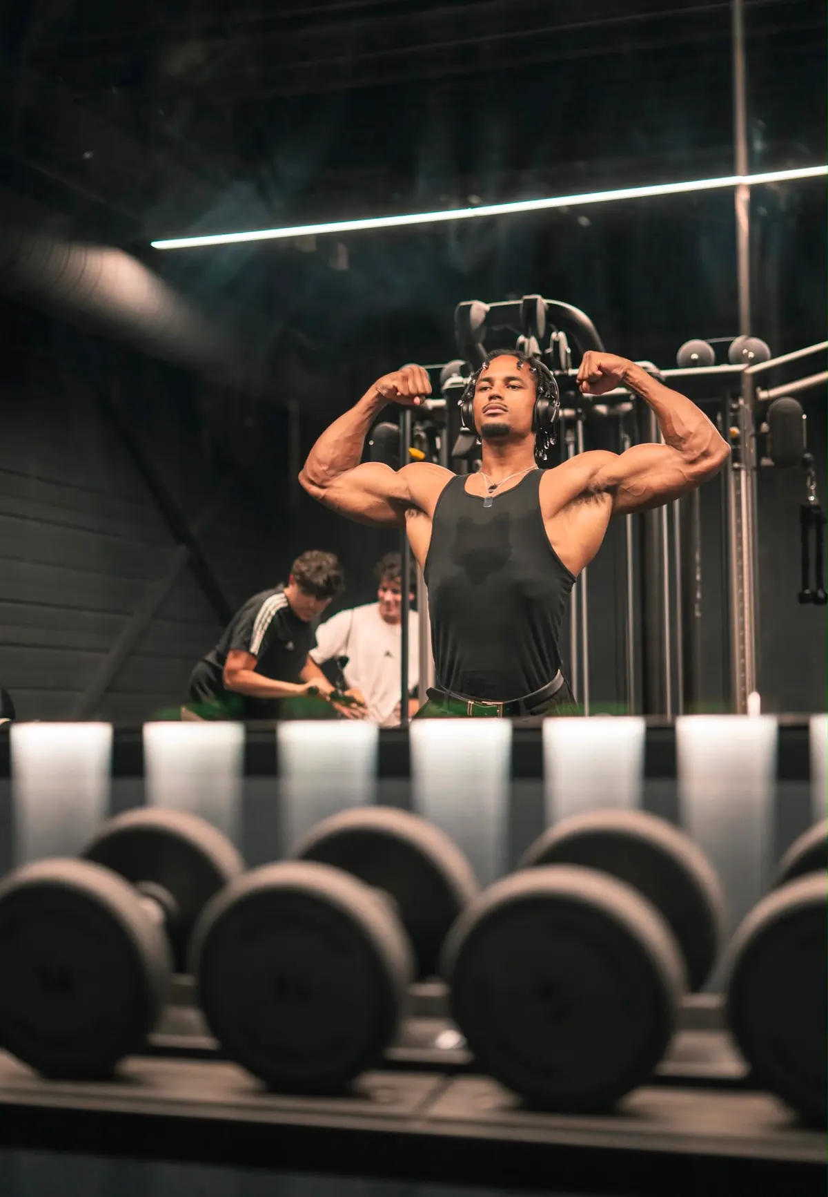 Tyron en pose double biceps dans une salle de musculation